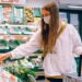 A woman chooses vegan options at a grocery store
